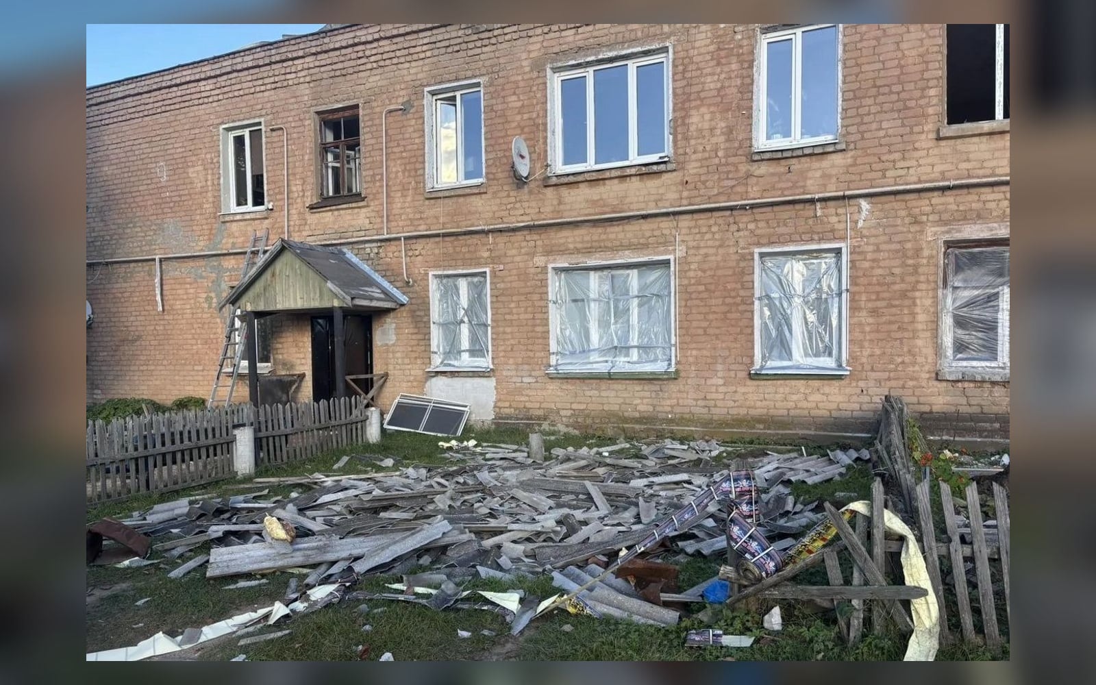 Дом в Кубринске: окна закрыты плёнкой, шифер с крыши во дворе