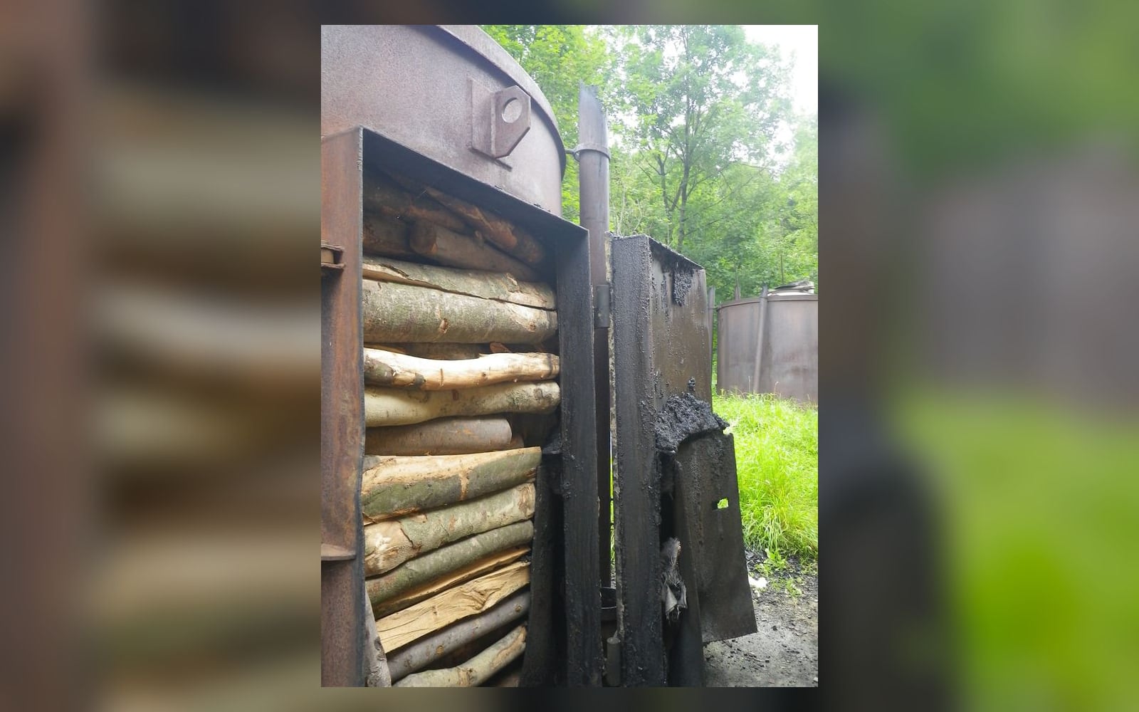 Загрузка дров в печь для производства древесного угля